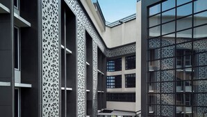 Un bâtiment moderne doté d’une cour intérieure aménagée avec des espaces de détente en plein air et une pelouse verdoyante.