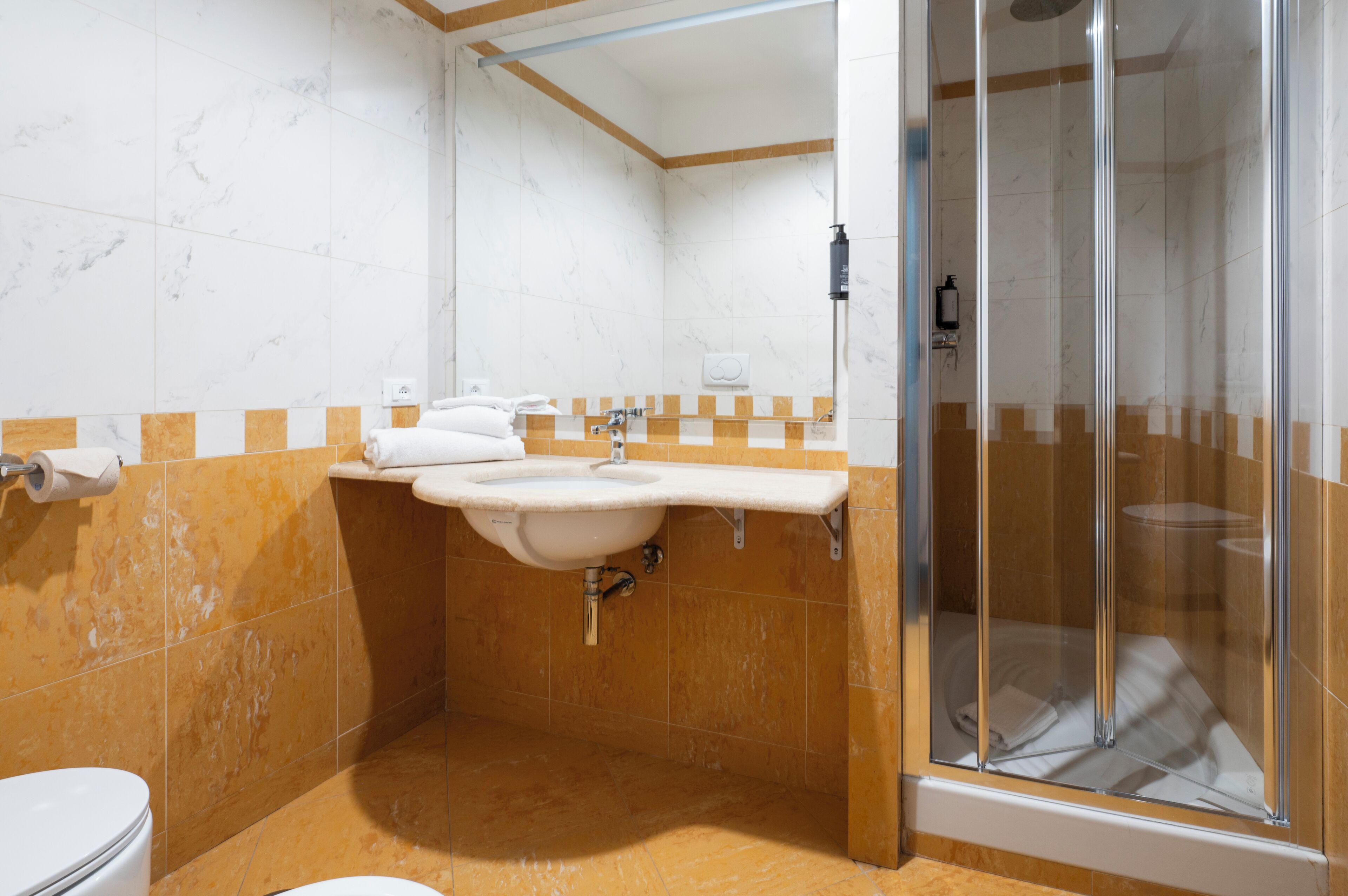 Un bagno con doccia, toilette e lavandino.