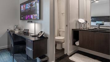 1 habitación, escritorio y tabla de planchar con plancha