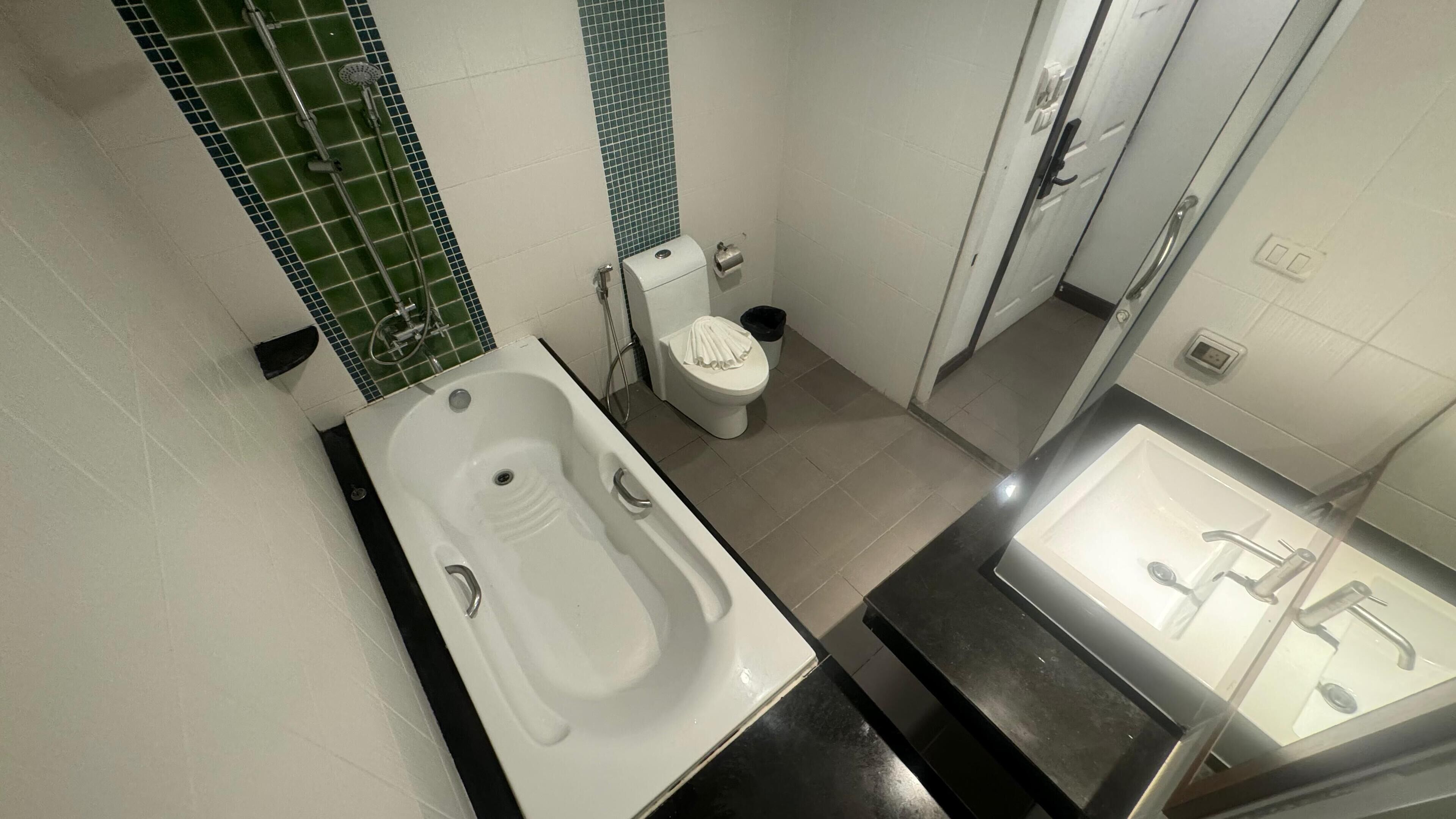A bathroom with a bathtub, toilet, and sink.