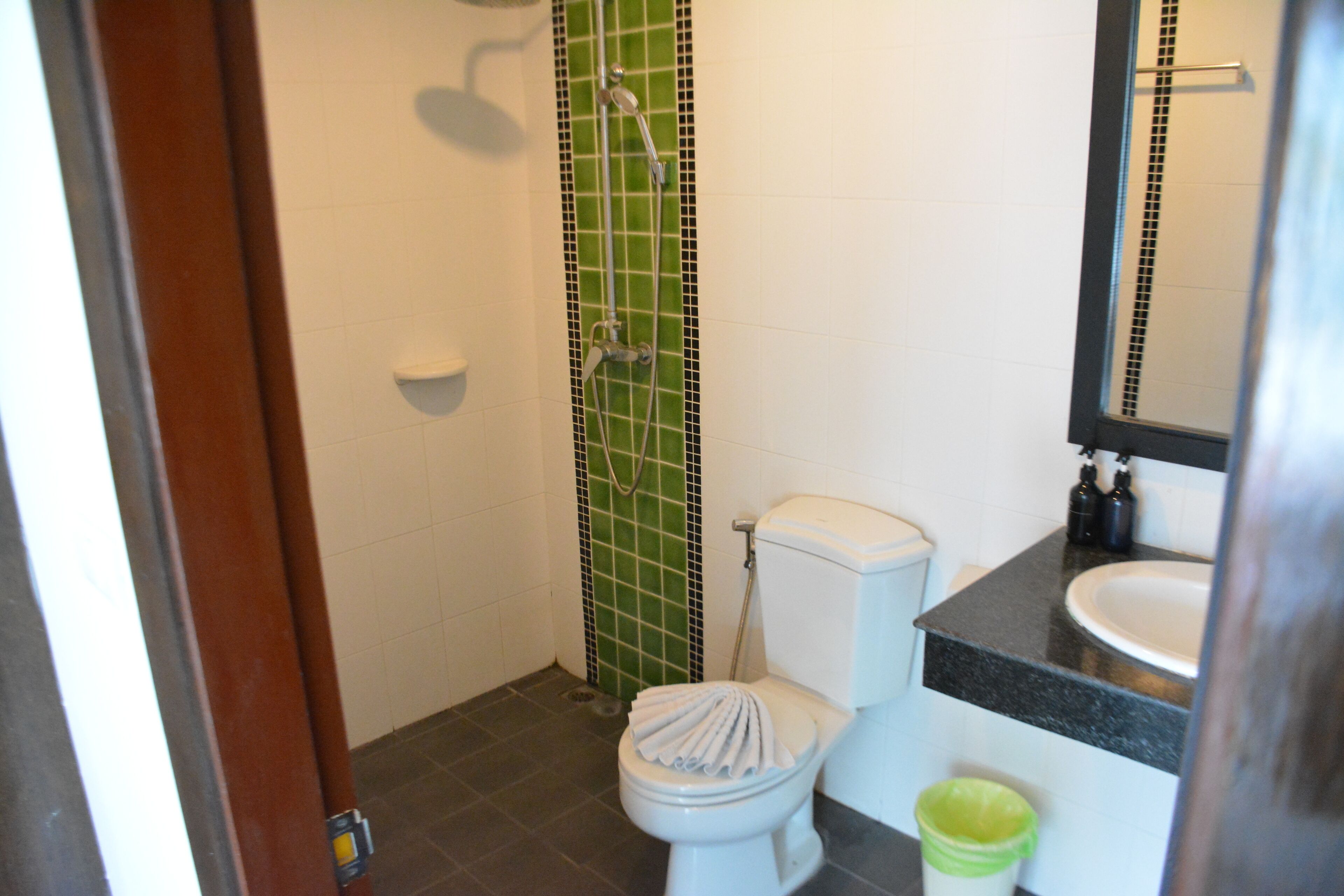A bathroom with a toilet, sink, and shower.