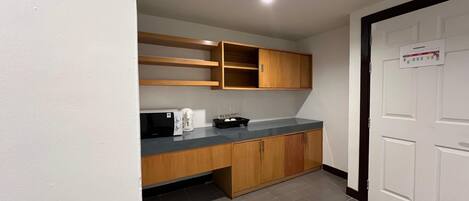A small kitchenette with a microwave, coffee maker, and a sink.