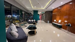 A modern lobby with a sofa, tables, and a reception desk. - Zephyr Grand Hotel (Patong)