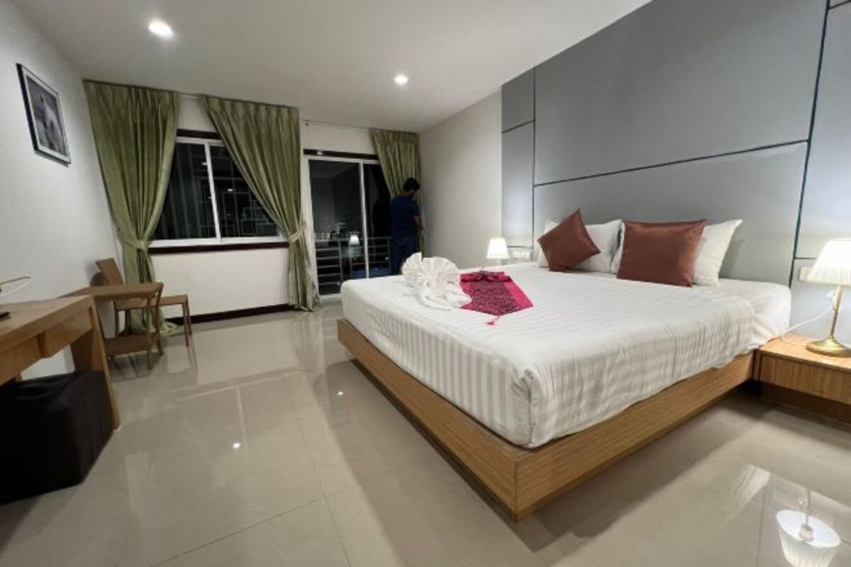 Une chambre d’hôtel moderne, dotée d’un grand lit, d’un bureau et d’une chaise.