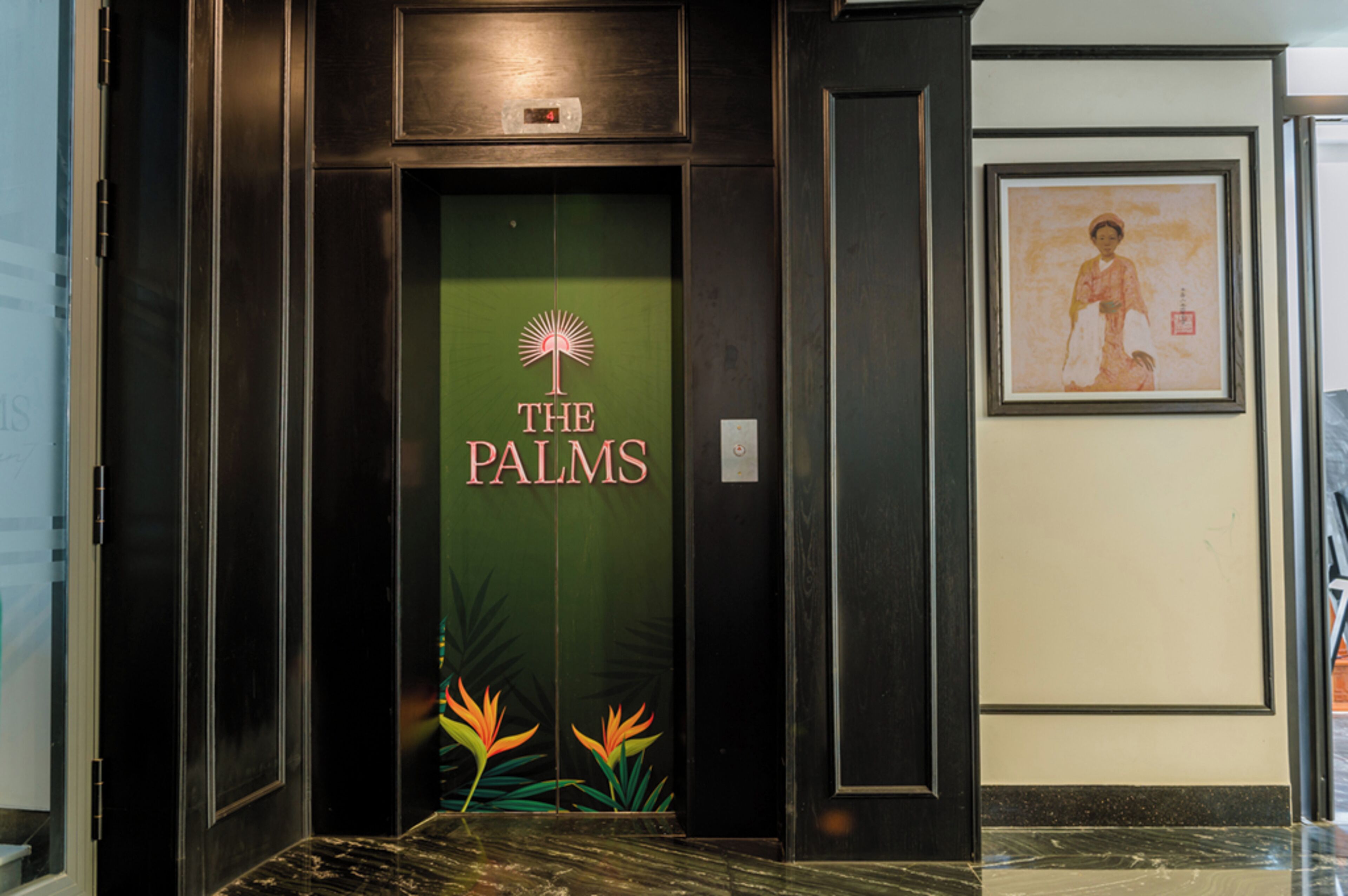 Un ascenseur avec une porte verte et l’inscription « THE PALMS » dessus.