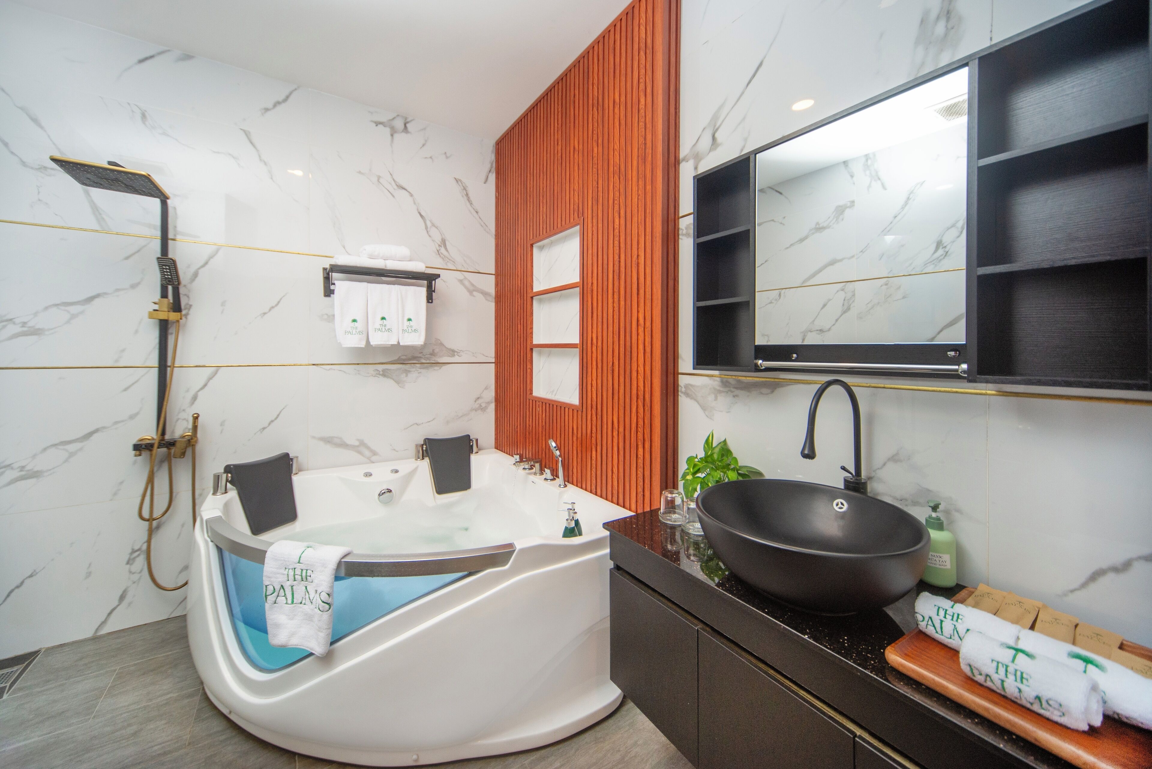 A modern bathroom with a freestanding bathtub, a large mirror, and a black basin.