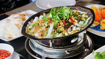 A hot pot meal with various ingredients and a side of white rice.