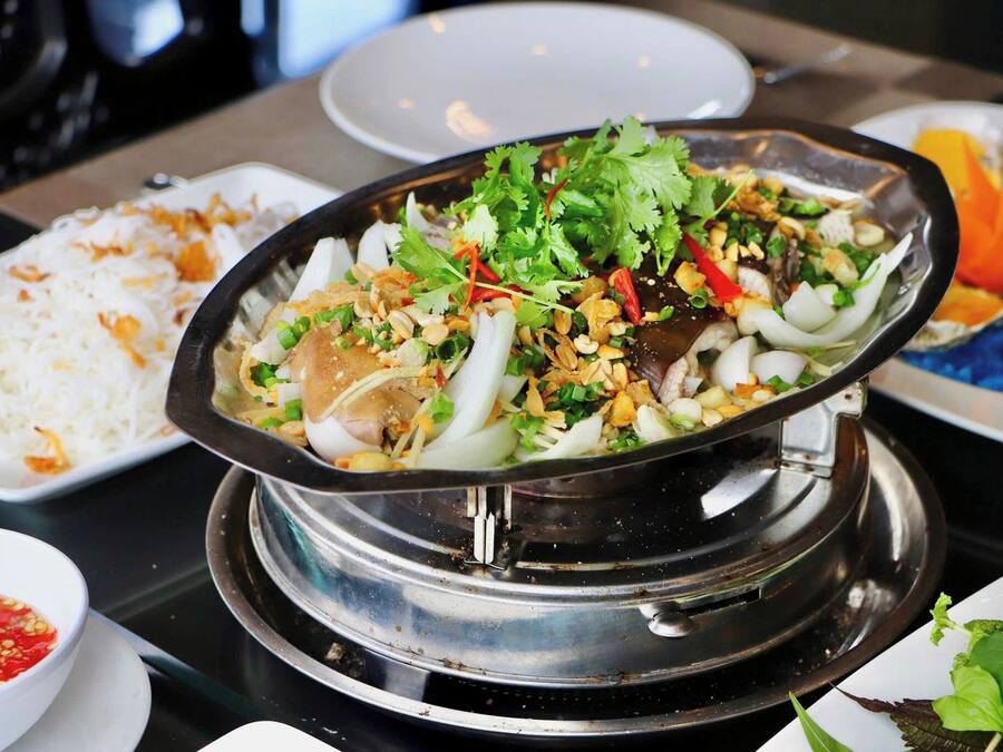 A hot pot meal with various ingredients and a side of white rice.
