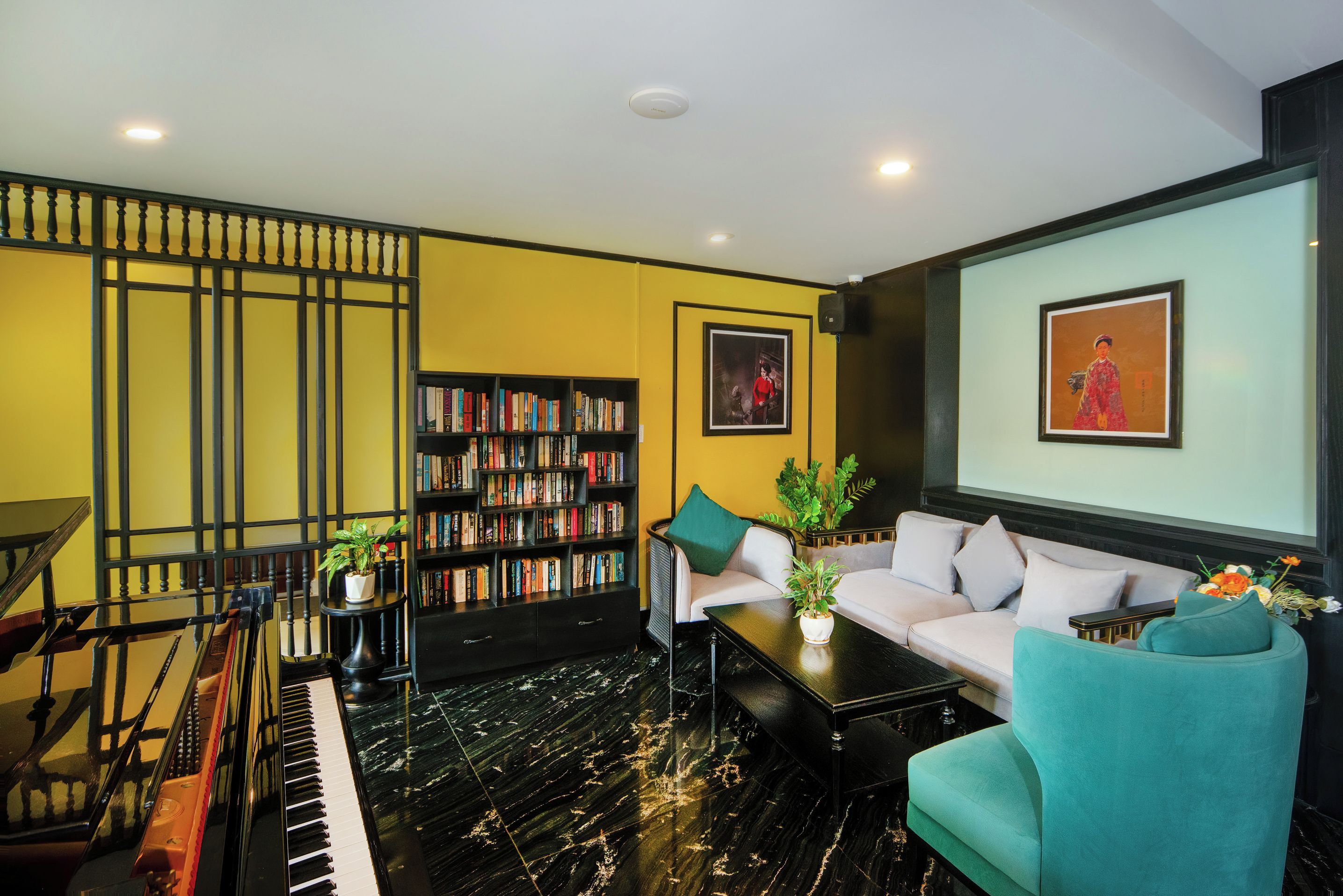A living room with a piano, a sofa, a coffee table, and a bookshelf.