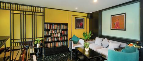 A living room with a piano, a sofa, a coffee table, and a bookshelf.