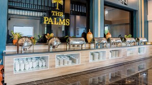 Un mostrador de buffet con varios dispensadores de comida y un letrero que dice 'The Palms'.
