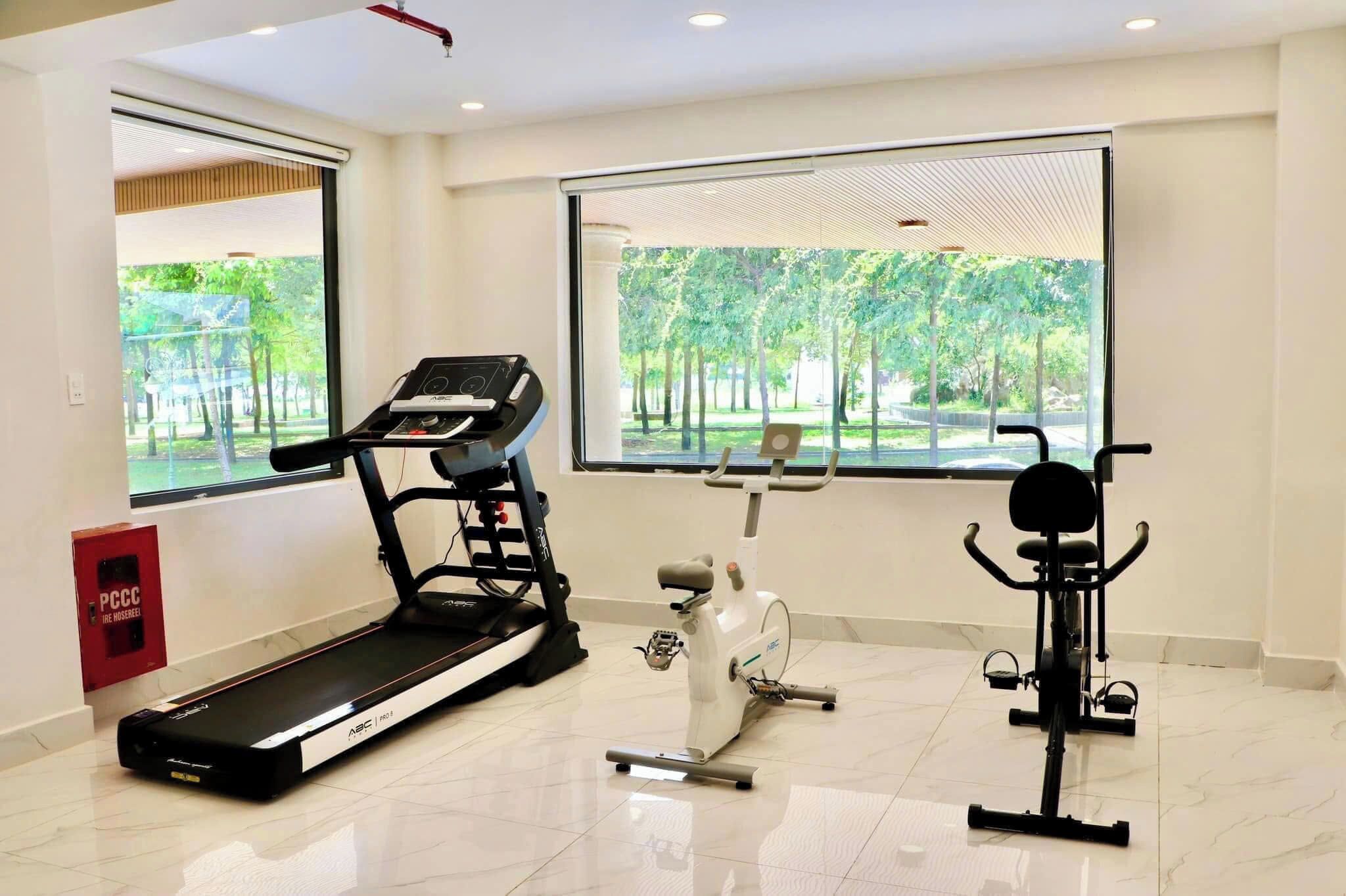 A gym with a treadmill, an elliptical, and a stationary bike.