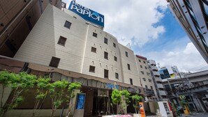 A hotel with a prominent sign, a tiled facade, and a parking area. - hoteru papion (Tokyo)