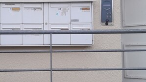Eine Gebäudefassade mit einem Schild, auf dem 'Résidence Caudères' steht, und einem Sicherheitstastfeld.
