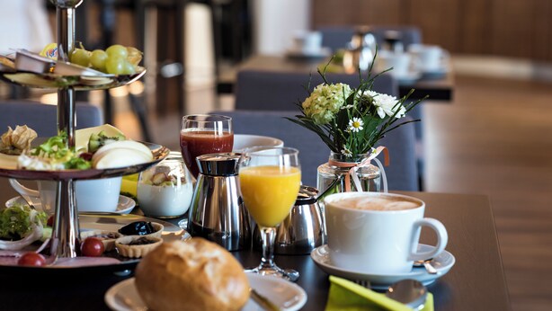 Een ontbijtsetting met verschillende soorten eten en drinken op een tafel.