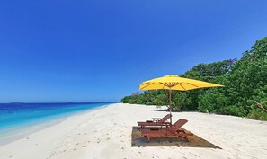 A beach with white sand, a yellow umbrella, and two wooden lounge chairs. - LHOHI INN BOUTIQUE HOTEL (Lhohi)