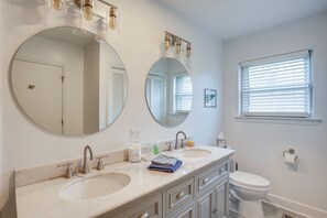 A bathroom with two sinks, a toilet, and a window with blinds. - Rossville Home Near Downtown & Lookout Mountain! (Rossville)
