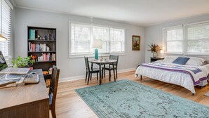 A bedroom with a bed, desk, bookshelf, and a dining table with chairs. - Rossville Home Near Downtown & Lookout Mountain! (Rossville)