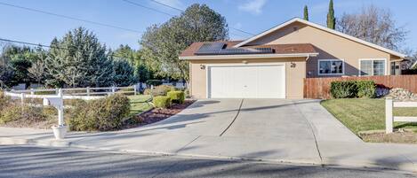 A single-story house with a garage, a driveway, and a fenced yard.