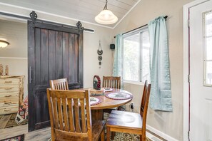 Enjoy meals in this cozy dining area with a wooden table and chairs, surrounded by natural charm.