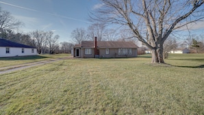 A single-story house with a front door, a chimney, and a large tree in front. - Quaint Youngstown Home ~ 2 Mi to Boardman Park! (Poland)