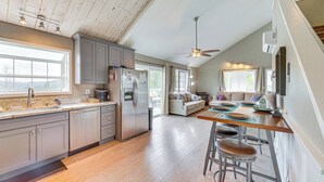 Une cuisine spacieuse avec un coin repas, un plancher en bois et un ventilateur de plafond.