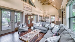 A spacious living room with a gray sectional sofa, a wooden coffee table, and a dining area with a table and chairs. - Riverfront Fishers Paradise in Florida w/ Dock! (Inglis)