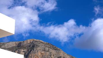 Una montaña con cielo azul despejado y algunas nubes.