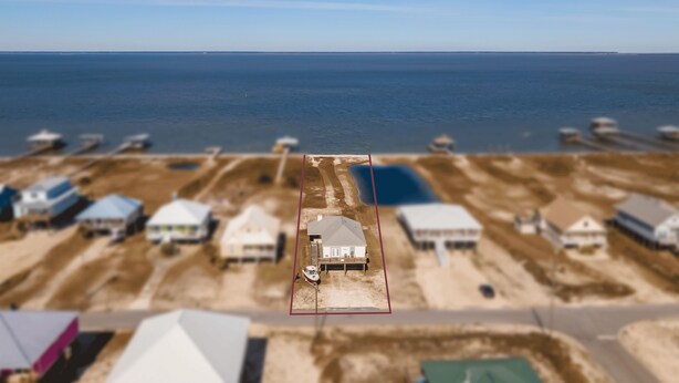 Vista aérea de una zona costera con varias casas y un muelle.