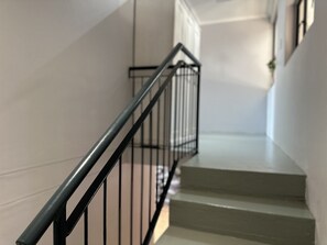 Staircase leading upwards with a black metal railing.
