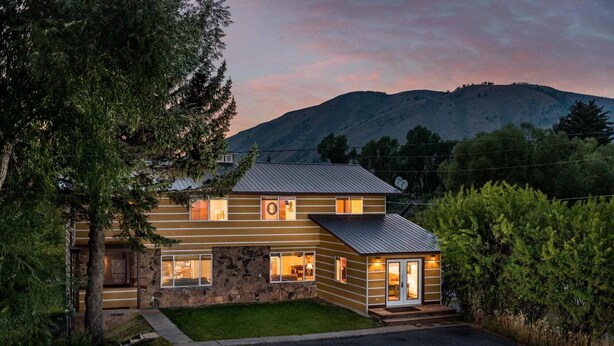 A two-story log cabin with a stone foundation, multiple windows, and a garage. - Outpost: Vine Street 2 - Close to Snow King! (Jackson)