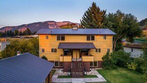A two-story wooden house with a front porch and a small garden. - Outpost: Vine Street 2 - Close to Snow King! (Jackson)