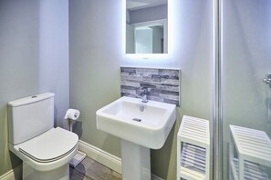 Bathroom features a pedestal sink, toilet, and towel rack.