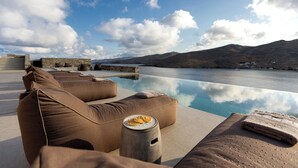 A poolside area with lounge chairs and a view of the water.