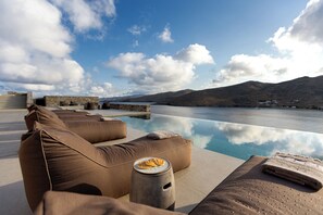 A poolside area with lounge chairs and a view of the water.
