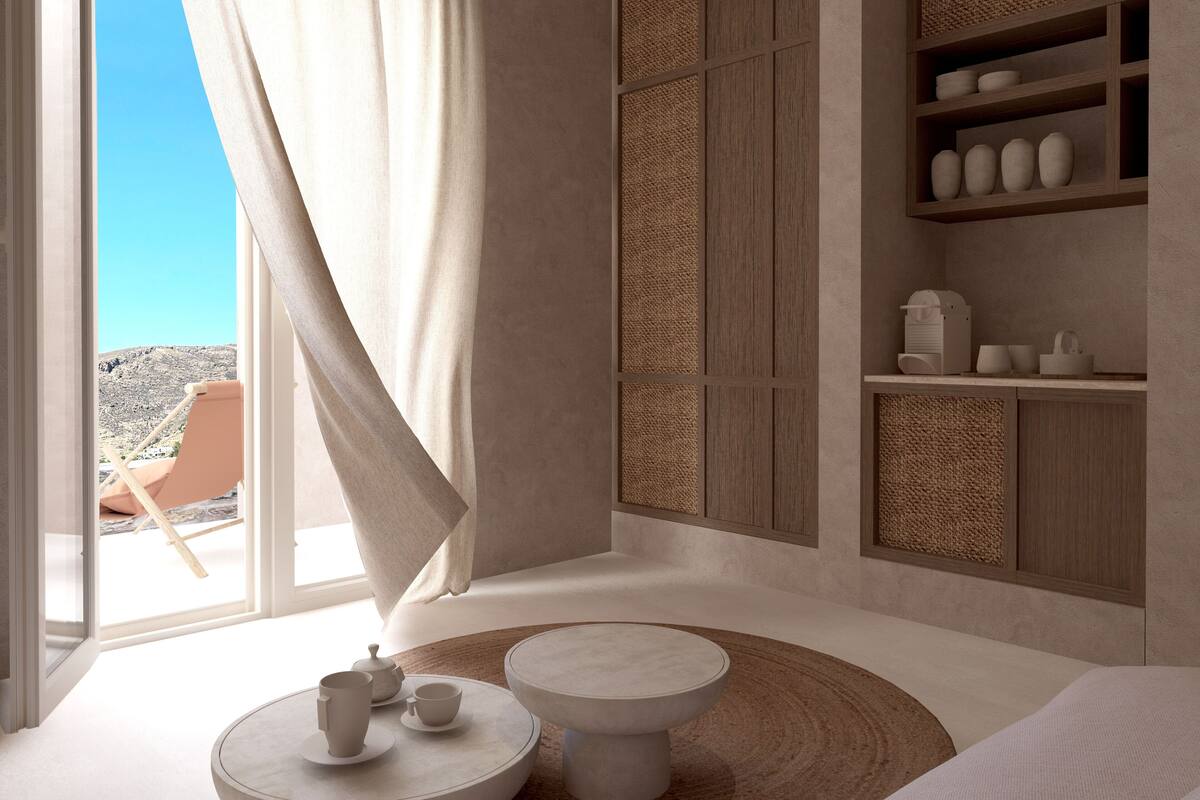 A modern room with a large window, a seating area with a round table, and built-in shelves with decorative items.