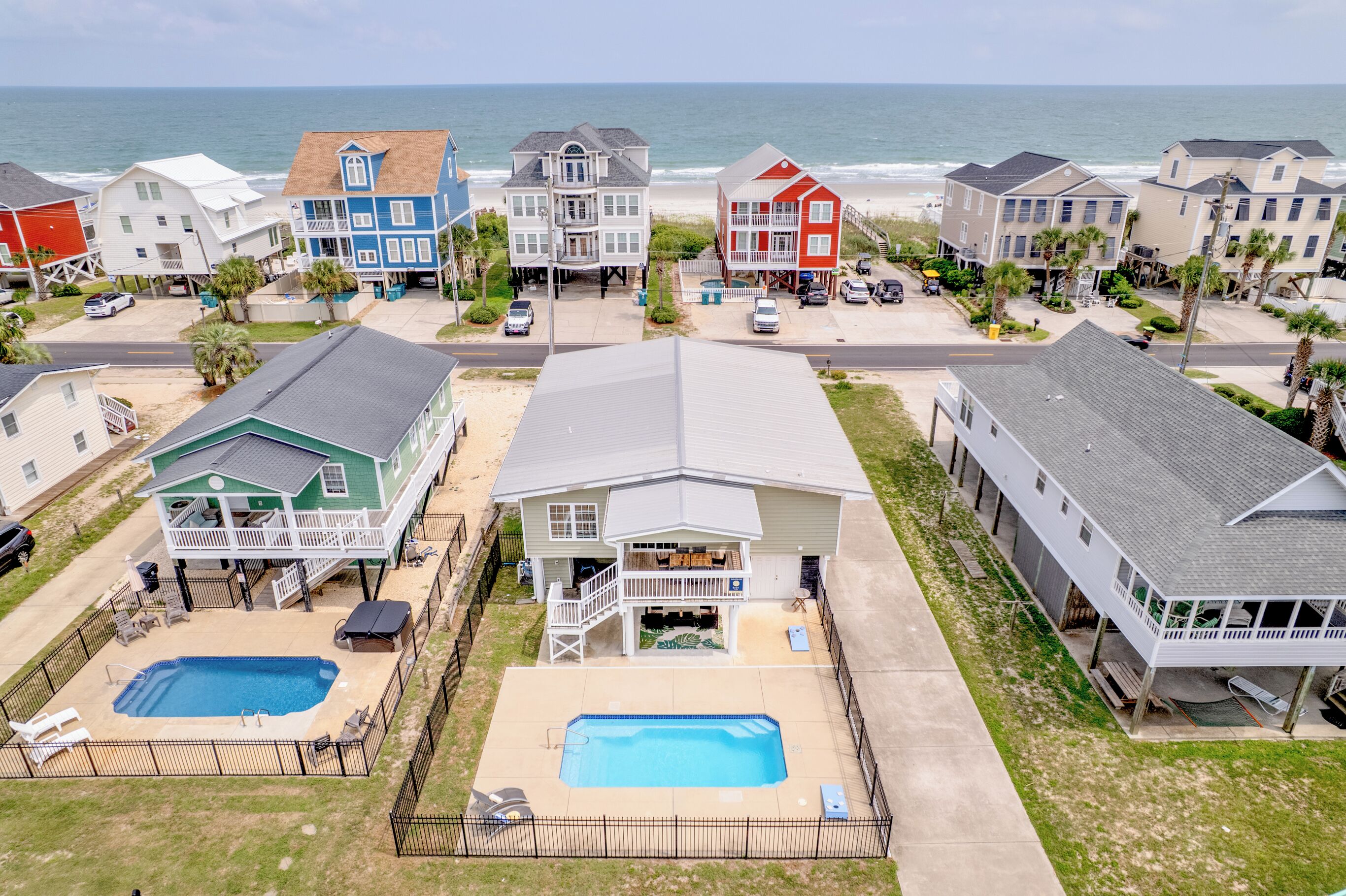 Zona residencial costera con casas, piscina y vista al mar.