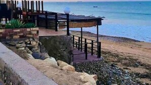 Une zone côtière dotée d’une structure en bois, peut-être un belvédère, qui offre une vue sur la mer.