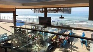 Un restaurant doté d’une balustrade en verre donnant sur l’océan.