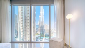 Ein modernes Hotelzimmer mit einem großen Fenster und Blick auf einen hohen Wolkenkratzer.