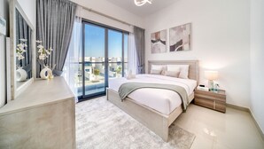 Une chambre moderne avec un grand lit, une table de chevet, une commode, un miroir et une vue sur la ville.