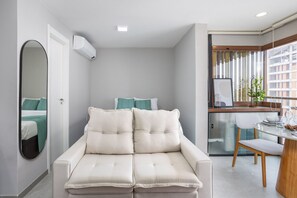 A compact living space with a sofa, a dining area, and a kitchenette.