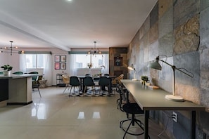 A modern kitchen with a dining area, stone wall, and pendant lighting. - Private Terrace Escape in the Heart of Roma Norte (Ciudad de México)