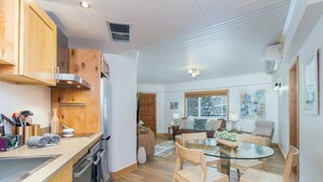 Una cucina moderna con mobili in legno, elettrodomestici in acciaio inossidabile e un tavolo da pranzo in vetro.
