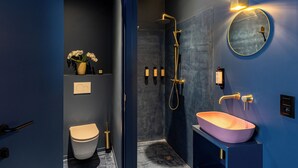 A modern bathroom with a toilet, a shower, and a sink with a round mirror. - The Mila Brussels (Brussels)