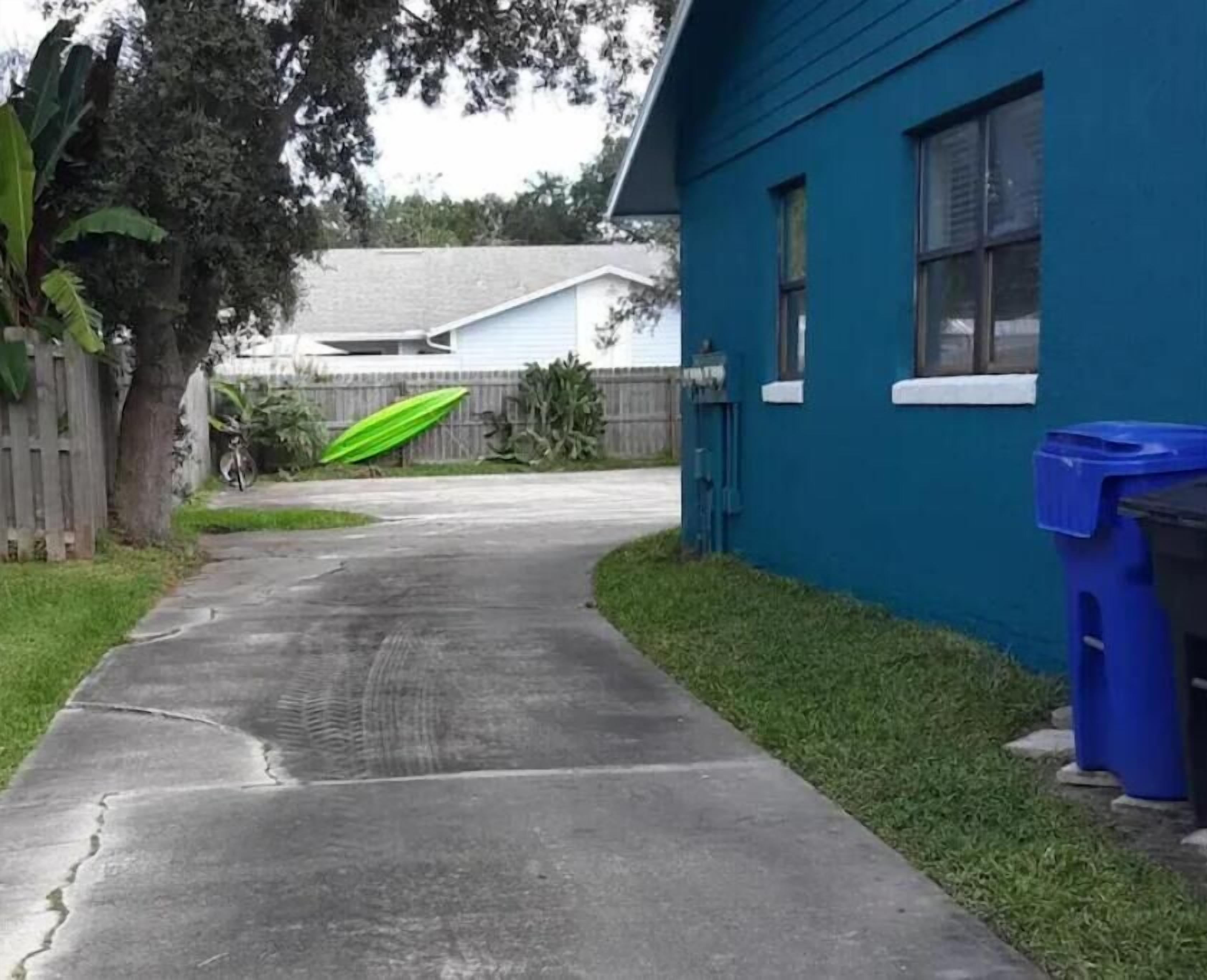 A residential driveway leading to a house with a blue exterior.
