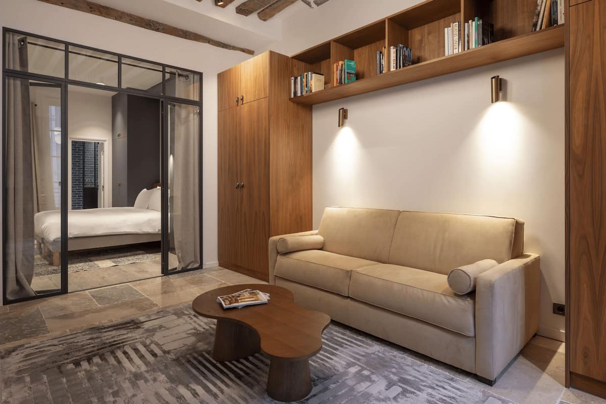 Una sala de estar moderna con un sofá, una mesita de centro y una estantería.