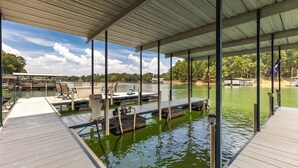 A covered dock area with a boat dock, seating, and a view of the water. - Moyers Landing - Lakefront Lake Hartwell with Doc (Anderson)