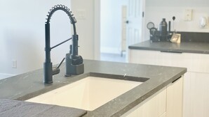 Une cuisine dotée d  ’un évier moderne, d’un robinet et d’un plan de travail.