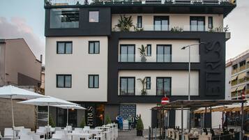A modern building with outdoor seating and a restaurant.